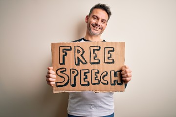 Young handsome man asking for rights holding banner with free speech message with a happy face...