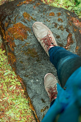woman legs in leather boots on te forest 