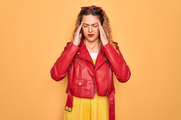 Young beautiful blonde woman pin-up with blue eyes wearing red sunglasses and jacket suffering from headache desperate and stressed because pain and migraine. Hands on head.