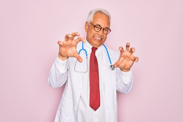 Middle age senior grey-haired doctor man wearing stethoscope and professional medical coat smiling...