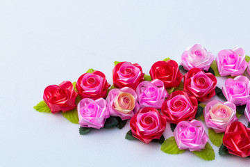 Fototapeta premium Artificial pink roses red on a white background.