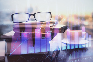 Financial graph hologram with glasses on the table background. Concept of business. Double exposure.