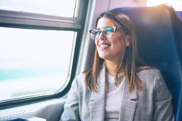 Young beautiful woman smiling happy and confident. Sitting with smile on face travelling by train