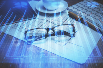 Financial chart hologram with glasses on the table background. Concept of business. Double exposure.