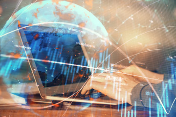 Double exposure of stock market graph with man working on laptop on background. Concept of financial analysis.