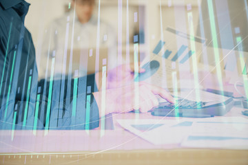 Double exposure of graph with man typing on computer in office on background. Concept of hard work....