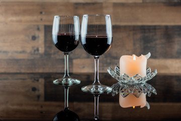 Two glasses of red wine by candlelight
