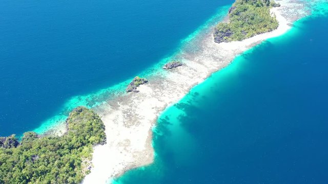 A remote, palm-covered island is found amid the gorgeous seascape in Raja Ampat, Indonesia. This amazing area is known for its marine biodiversity, world class scuba diving and snorkeling.
