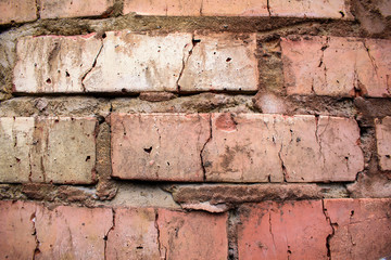 Old brick wall for backdrop. Thick joints made of concrete, cracks. Close-up. Shades of gray and red.