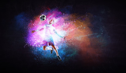 Boy playing soccer hitting the ball