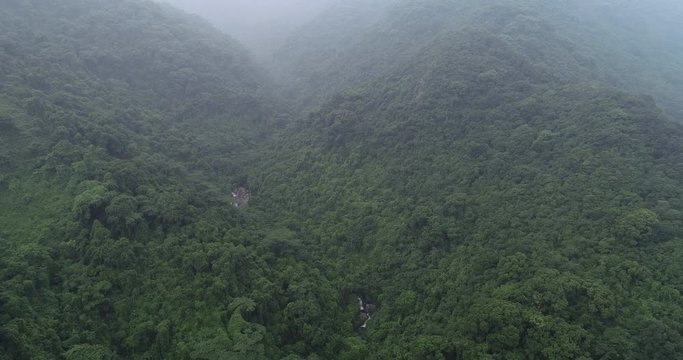 Aerial view of waterfall flowing in the tropical rainforest mountains