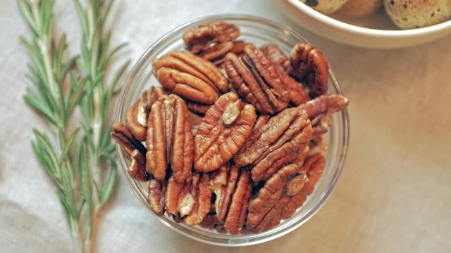 pecans in a bowl that rotates clockwise on the served holiday table, top view, close-up