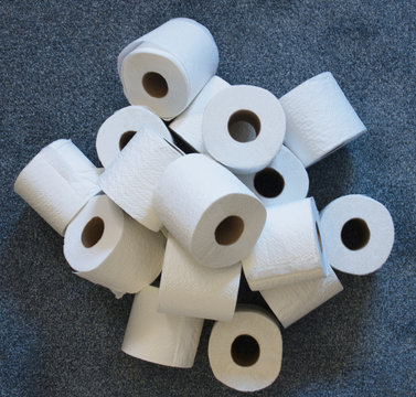 Pile of toilet paper rolls on carpet