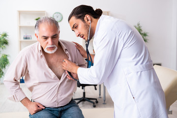 Fototapeta premium Old man visiting young male doctor cardiologist