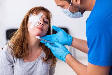 Young head injured woman visiting young male doctor