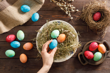 Still life many colorful easter eggs on a wooden background. Rustic. Decoration from natural fabrics and herbs. Easter celebration concept. Flat lay