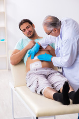 Injured young man visiting experienced male doctor
