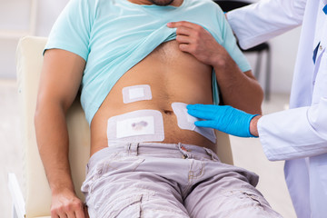 Injured young man visiting experienced male doctor