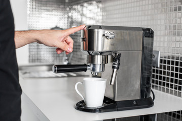 Guy prepare delicious aromatic coffee in a coffee machine. A simple way to make coffee