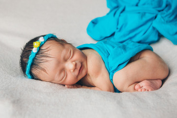 portrait of a sleeping newborn baby in a headband with flower. Health concept: IVF, baby accessories