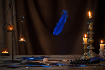 fortune-telling cards and burning candles on a wooden table on  dark brown background