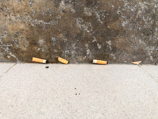 Smokers are littering cigarette butts on the public.