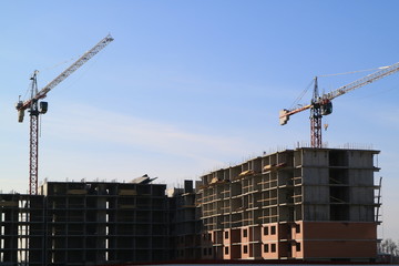 Tower cranes are working on the construction of a new house. Lifting crane.