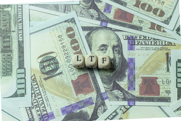 ltf  wooden cube on banknotes for business content.