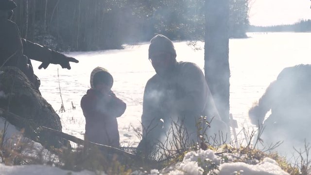 Hiking multi generation family, cooking food at campfire