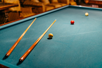 billiard table with balls and cues