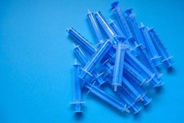 Medicine and health concept. Blue plastic syringes close-up on a  blue background. Vaccination and...