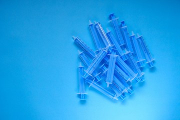 Medicine and health concept. Blue plastic syringes  on a bright blue background. Vaccination and vaccinations