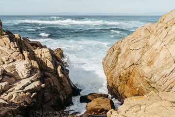 Fototapeta na wymiar Waves Crashing Between Boulders