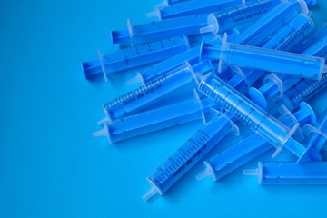 Medicine and health concept. Blue  syringes close-up on a bright blue background. Vaccination and...