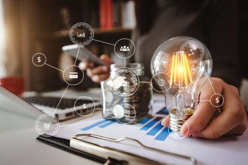 business man using smartphone, tablet and holding light bulb, with idea with innovation and creativity