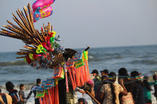 Chennai, Tamilnadu / India - December 25 2019: toys seller young man selling toys in the beach
