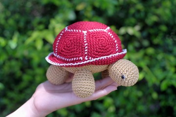 The stuffed turtle is made of knitted yarn, a beautiful and still popular classic technique