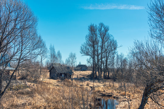 Rural Landscape With A Small River And Abandoned Rural Buildings In Backlit