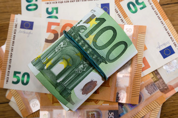 100 euros twisted roll on a euro background. View from above. Close-up.