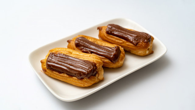 plate cakes chocolate icing on white background