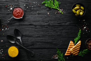 The background of cooking. A set of spices and fresh vegetables. Top view. Free space for your text. On a black stone background.