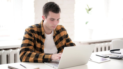 The Casual Young Man Typing on Laptop
