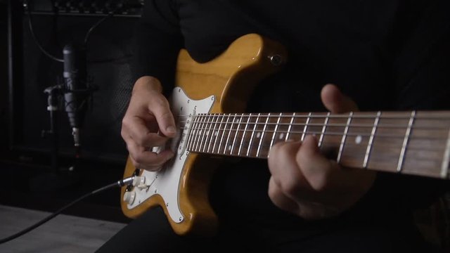 guitarist plays guitar at studio on record. slow motion 50p