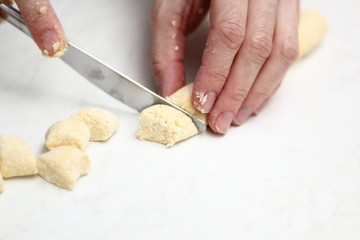 Gnocchi being prepared. Cutting dough. Dough dumplings with cheese.
