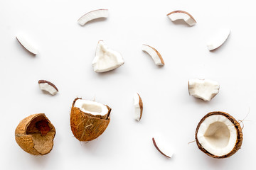 Coconuts pieces background on white table top-down