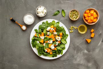 Cooking salad with pumpkin and basil. Ingredients on grey background top-down