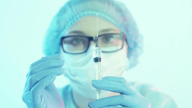 Coronavirus vaccine. Healthcare service. Female doctor preparing syringe for injection.