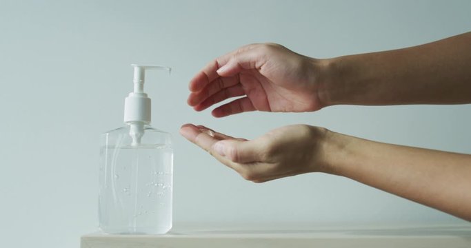 Hand sanitizer alcohol gel rub clean hands hygiene prevention of coronavirus virus outbreak. Woman using bottle of antibacterial sanitiser soap. Slow motion on RED cinema camera.