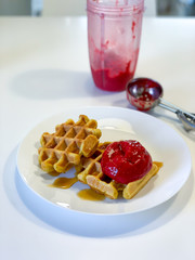Fresh belgian waffles with berry ice cream in a white plate