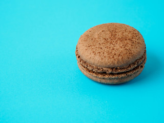 French macaron isolated on blue background.